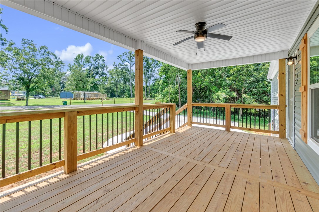 108 Old River Road Iva, SC 29655 - Photo 3 of 31 An inviting covered porch extends outdoor living space, featuring a natural wood deck and verdant views.