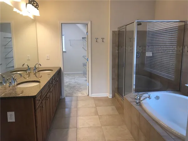 a bathroom with a granite countertop sink a mirror and a bathtub
