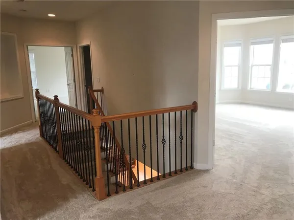a view of a hallway with windows and stairs