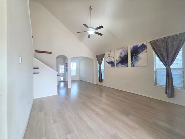 a view of a livingroom with wooden floor and a ceiling fan