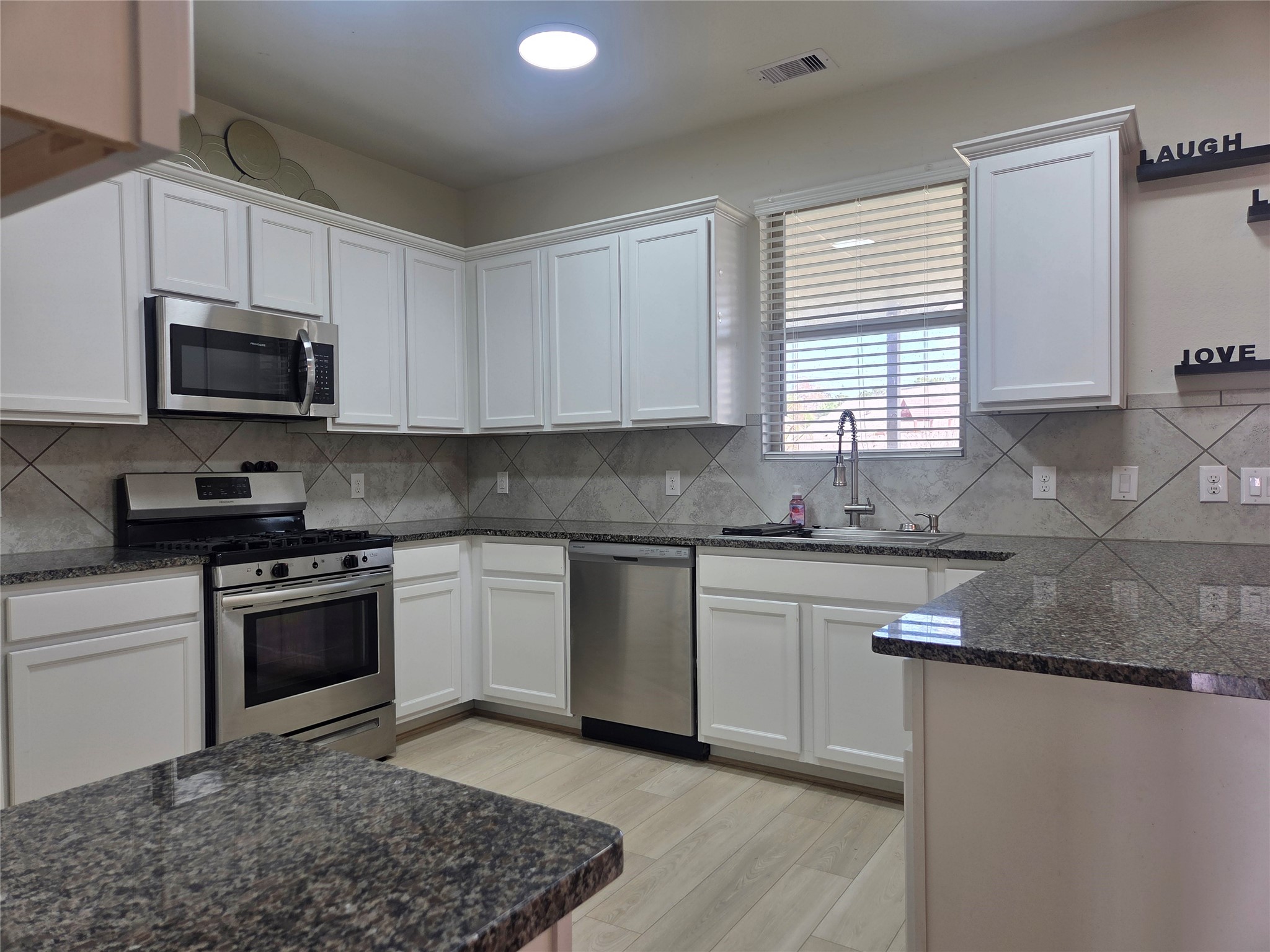 28137 Aspen Horizon Drive Spring, TX 77386 - Photo 5 of 33 a kitchen with stainless steel appliances granite countertop a sink a stove a microwave and cabinets