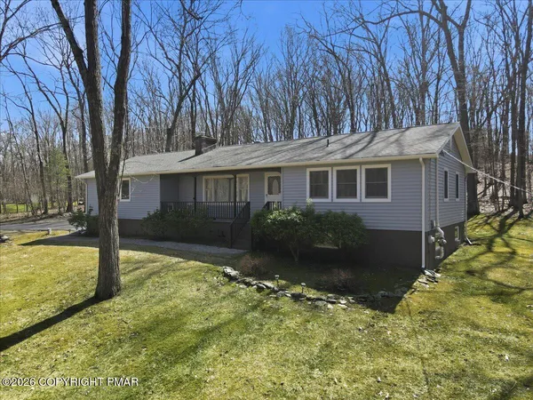 a view of a house with a yard covered in snow