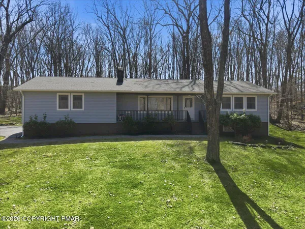 a view of a house with a big yard and large tree