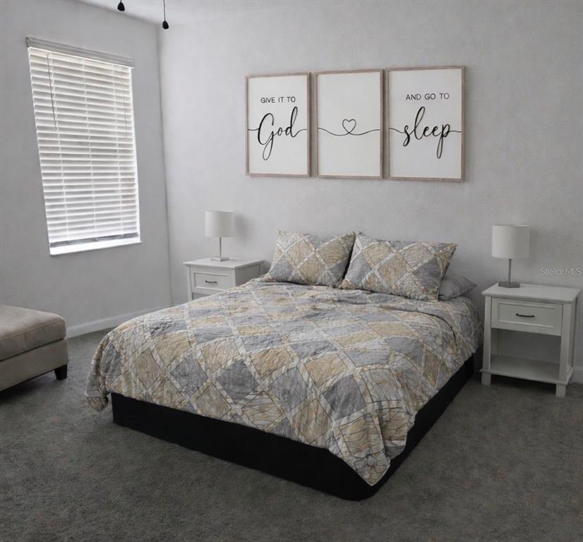 1054 John Jacob Road Davenport, FL 33837 - Photo 3 of 16 a bed sitting in a bedroom next to a window