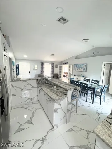 a large kitchen with a table and chairs