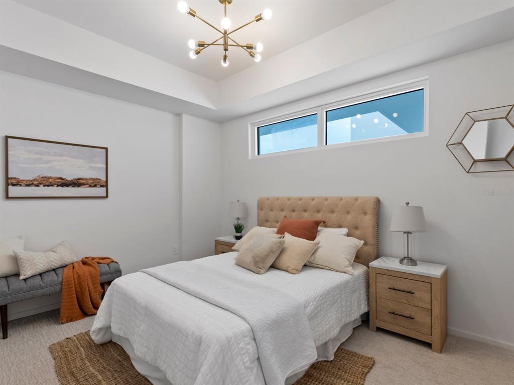 1020 Sunset Point Road, Unit 410 Clearwater, FL 33755 - Photo 25 of 27 a bedroom with furniture and a chandelier