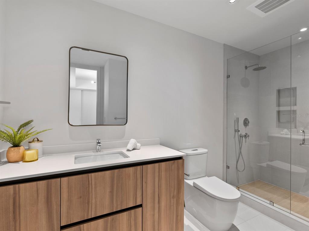 1020 Sunset Point Road, Unit 410 Clearwater, FL 33755 - Photo 27 of 27 a bathroom with a double vanity sink toilet and shower
