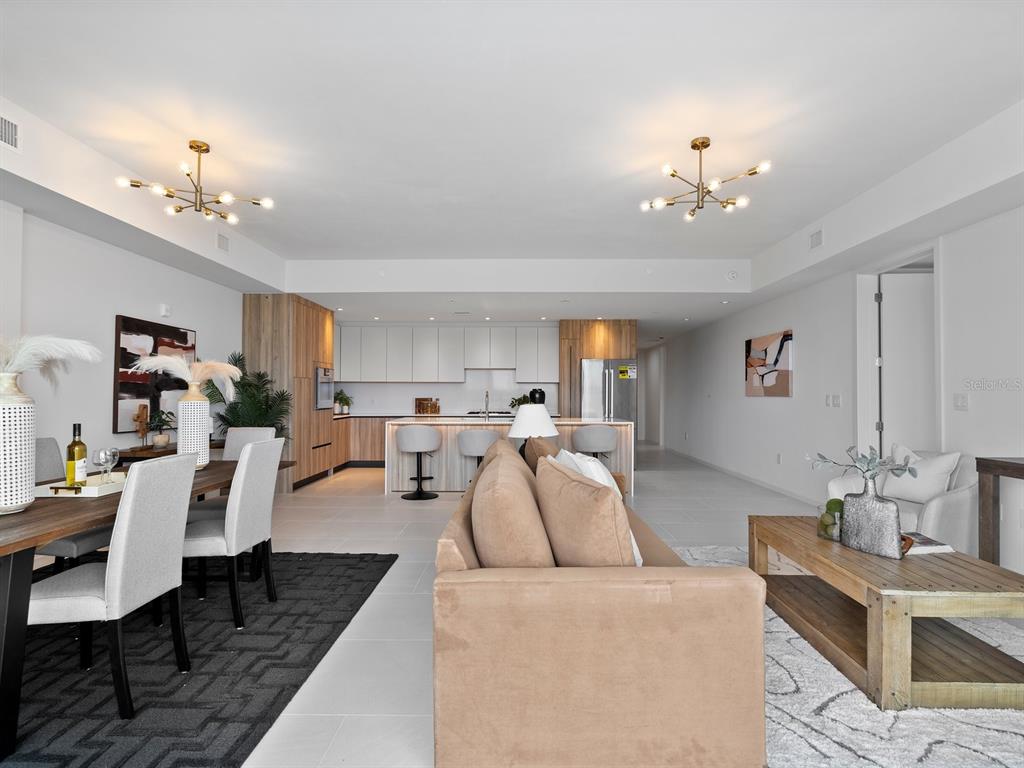 1020 Sunset Point Road, Unit 410 Clearwater, FL 33755 - Photo 7 of 27 a living room with furniture a chandelier and a dining table