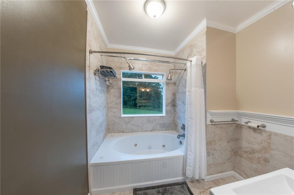 1815 Pickens Street Ball Ground, GA 30107 - Photo 16 of 38 a bathroom with a bathtub and a shower