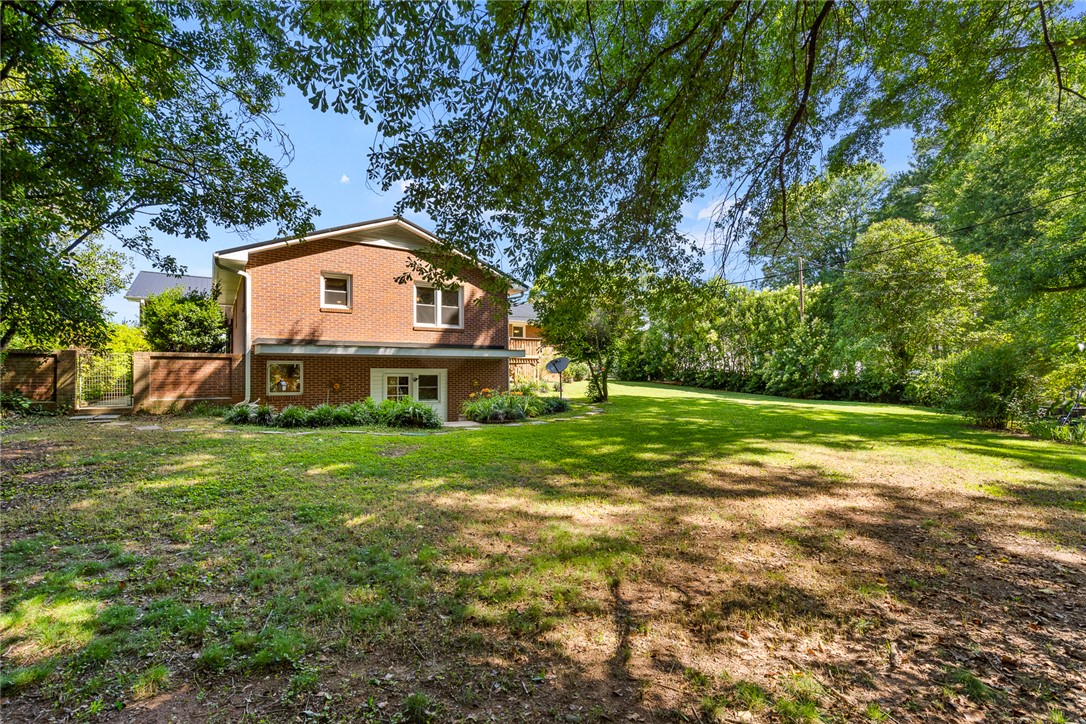 512 East Fredericks Street Anderson, SC 29621 - Photo 28 of 31 Mature trees frame this brick residence with a verdant yard.