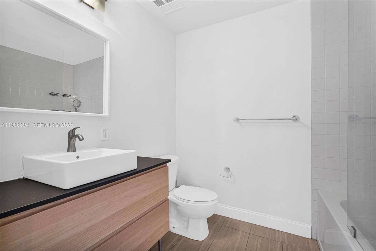 10 Southwest South River Drive, Unit 1615 Miami, FL 33130 - Photo 14 of 28 a bathroom with a sink a toilet and a mirror