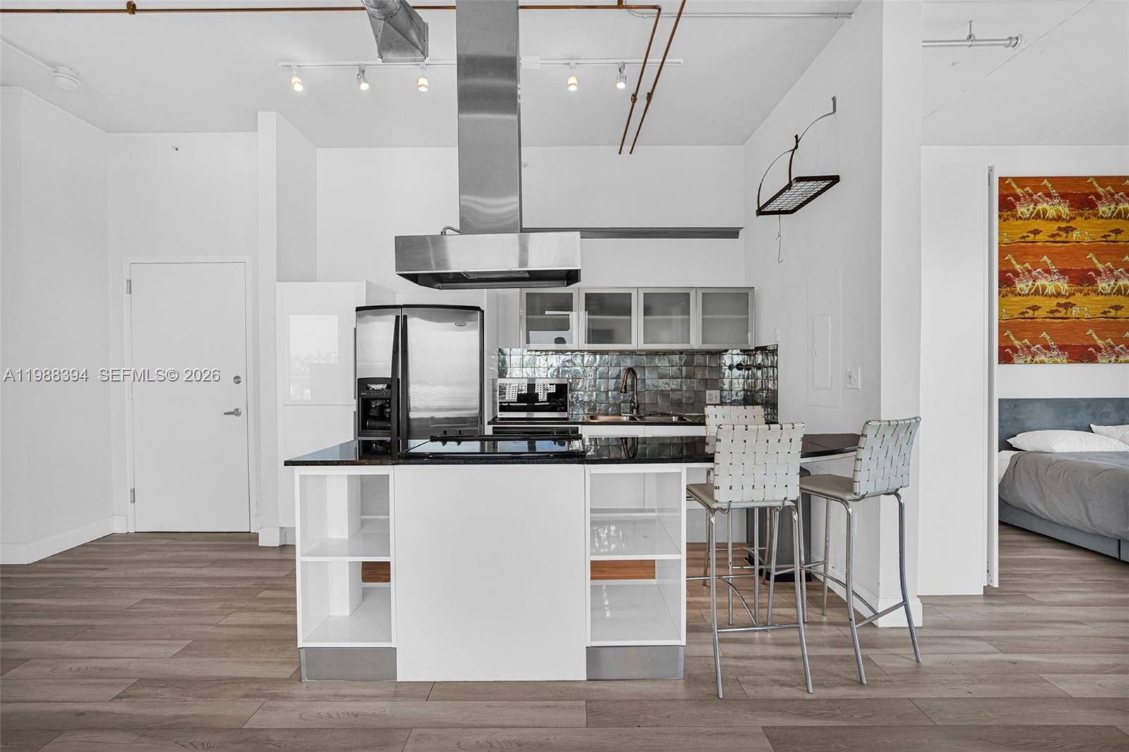 10 Southwest South River Drive, Unit 1615 Miami, FL 33130 - Photo 5 of 28 a kitchen with stainless steel appliances kitchen island granite countertop a table and chairs in it