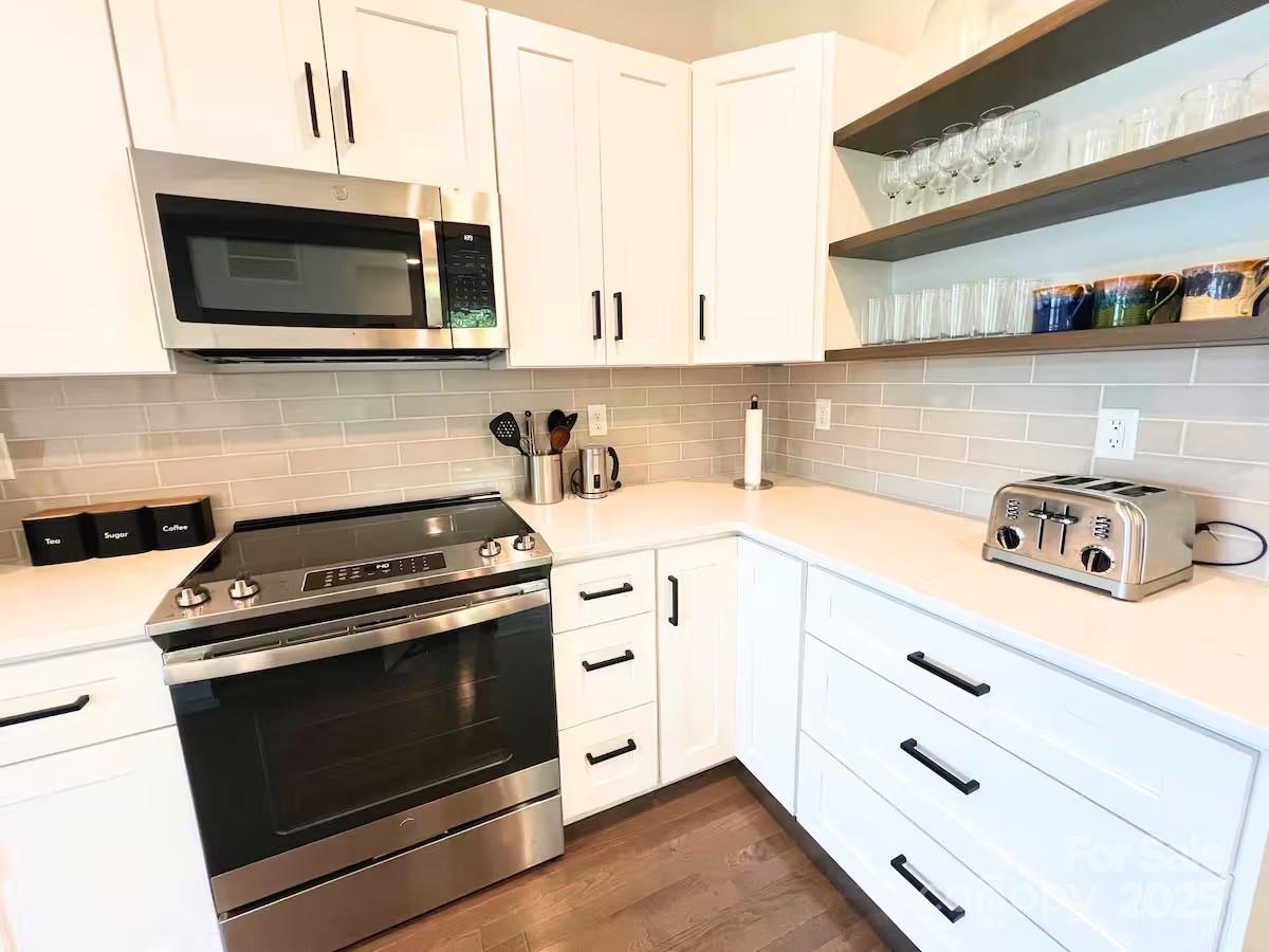 1057 Riverside Drive Asheville, NC 28804 - Photo 11 of 42 a kitchen with stainless steel appliances a stove a microwave and cabinets