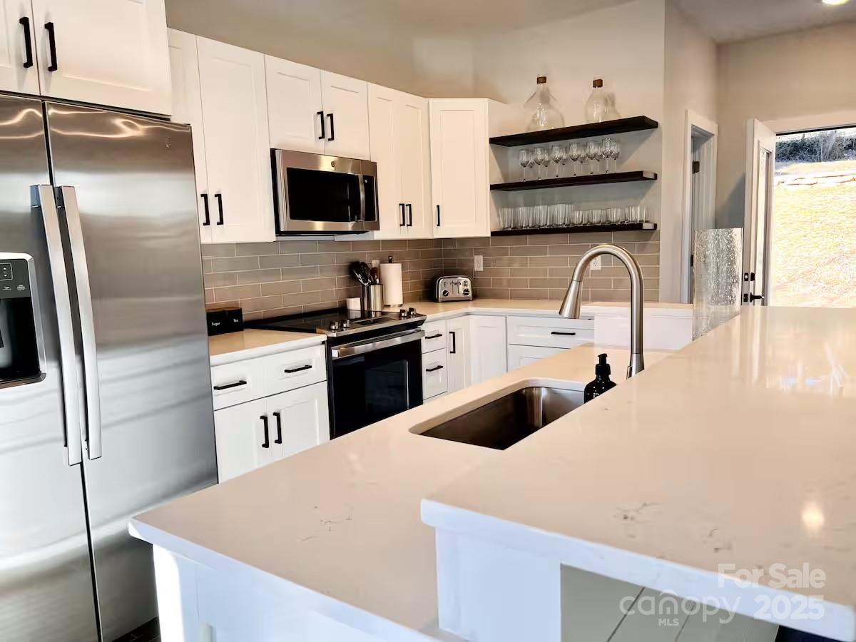 1057 Riverside Drive Asheville, NC 28804 - Photo 13 of 42 a kitchen with stainless steel appliances a refrigerator sink and microwave