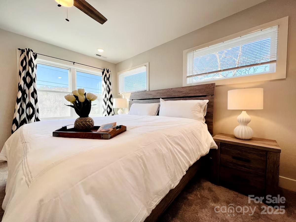 1057 Riverside Drive Asheville, NC 28804 - Photo 21 of 42 a bedroom with a bed and lamp with window