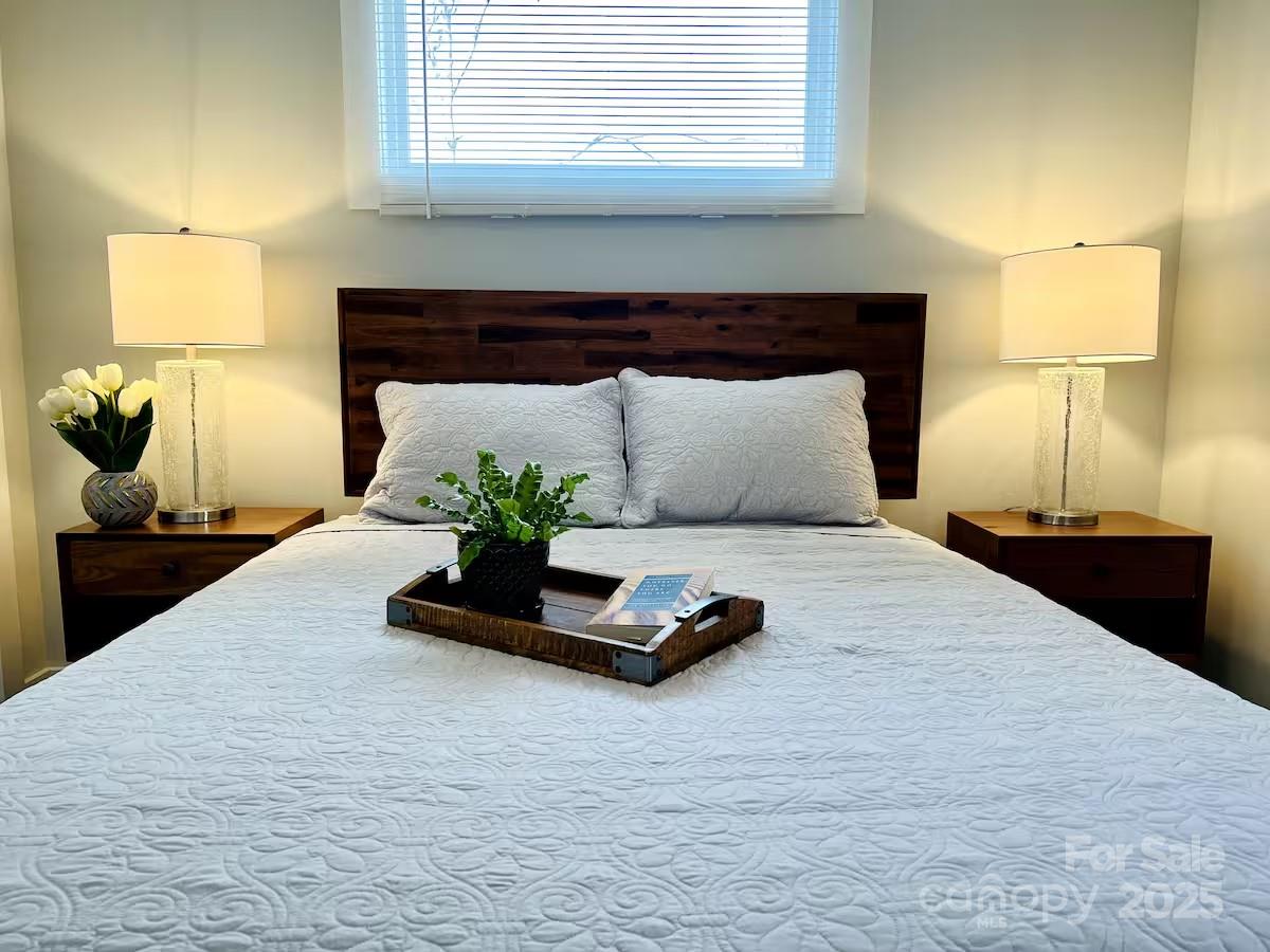 1057 Riverside Drive Asheville, NC 28804 - Photo 25 of 42 a bedroom with a bed and lamp