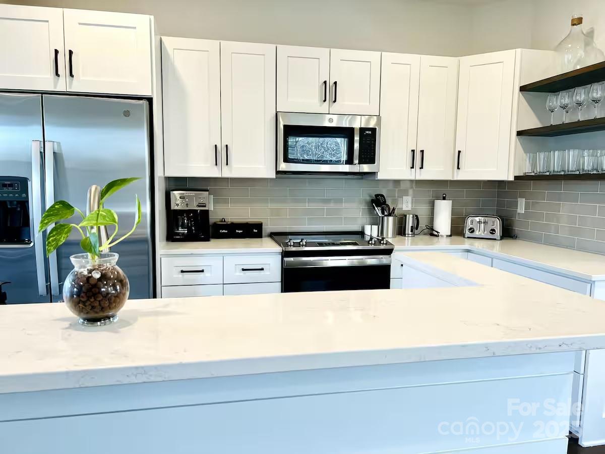1057 Riverside Drive Asheville, NC 28804 - Photo 10 of 42 a kitchen with kitchen island a sink a stove and a microwave