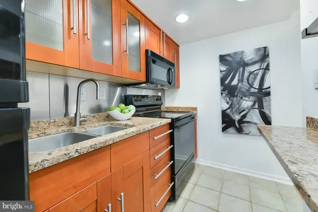 a kitchen with stainless steel appliances granite countertop a sink stove and cabinets