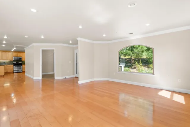 an empty room with wooden floor and a window
