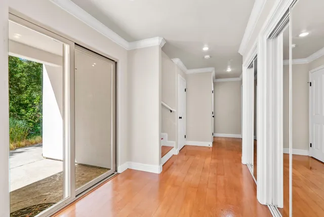 a view of empty room with wooden floor