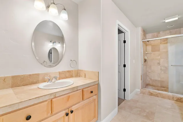a bathroom with a granite countertop toilet a sink and a mirror