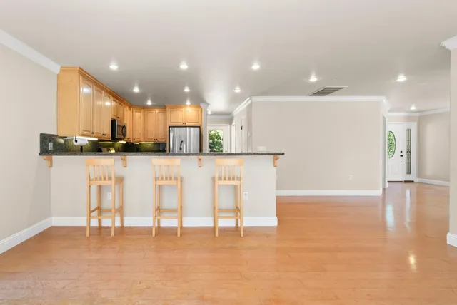 a view of a kitchen with kitchen island stainless steel appliances refrigerator stove microwave and cabinets