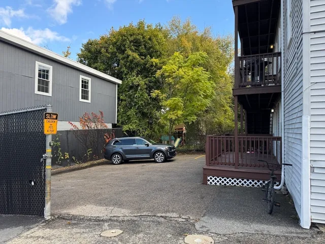 a view of a street with a car parked beside it