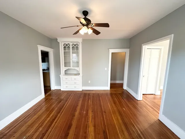 a view of a livingroom with wooden floor and a ceiling fan