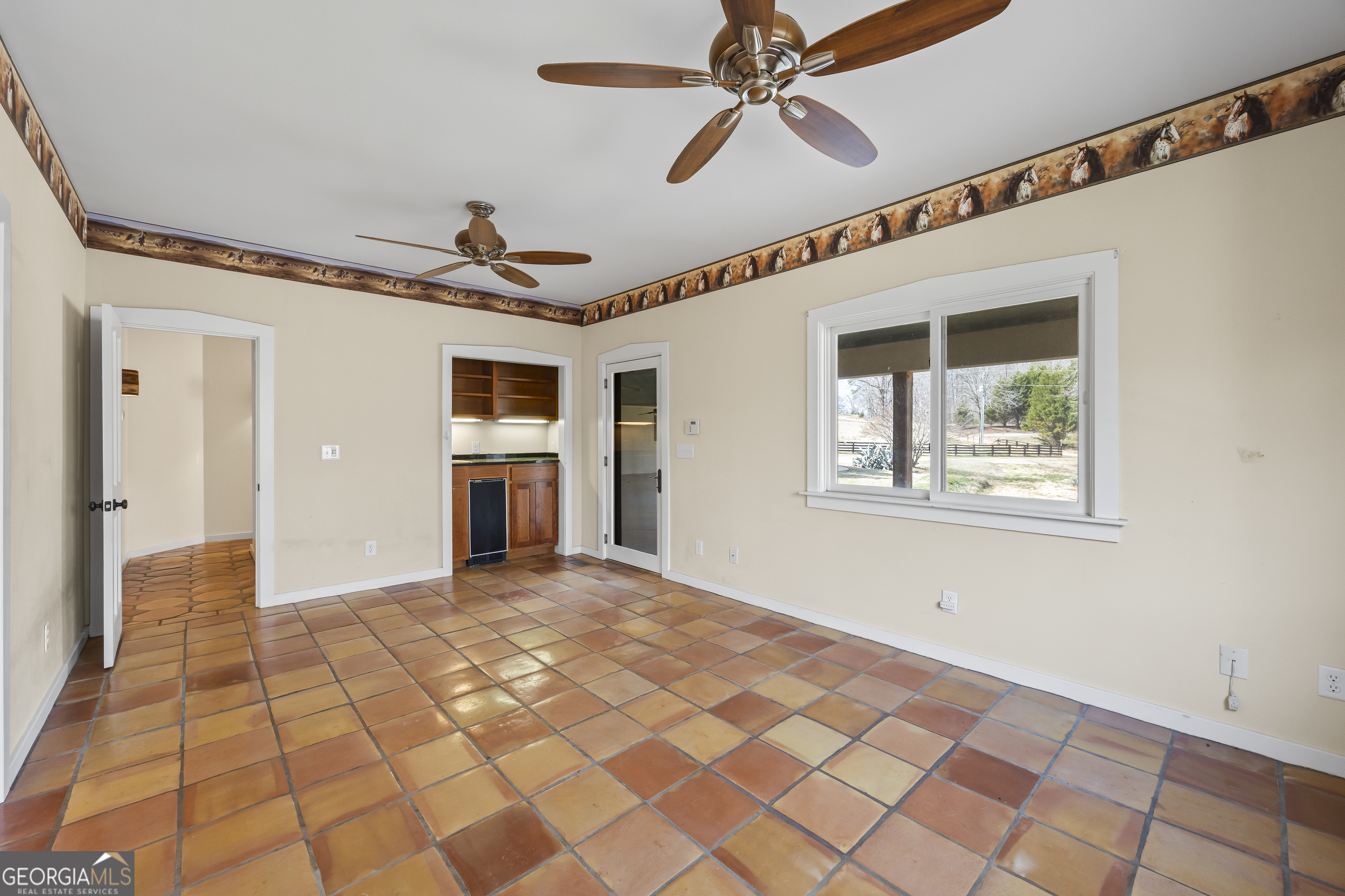2223 Salem Road Watkinsville, GA 30677 - Photo 22 of 94 a view of a big room with wooden floor a ceiling fan and windows