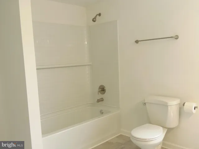 a white toilet sitting next to a bath tub