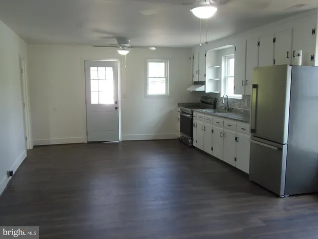 a kitchen with stainless steel appliances granite countertop a refrigerator a sink dishwasher a stove and a refrigerator