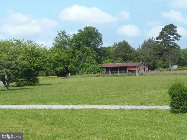 a view of a green field with wooden fence