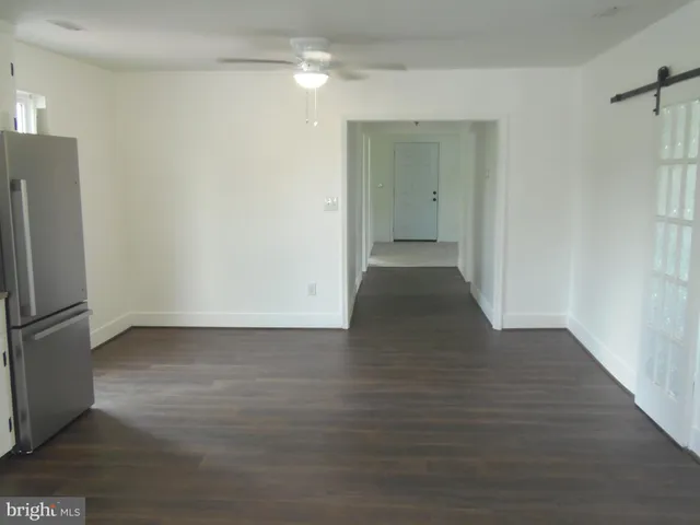 a view of a kitchen with wooden floor and a refrigerator