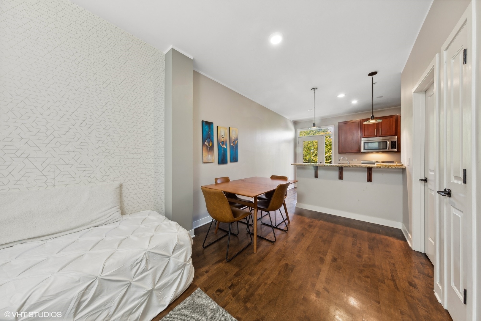 1244 West Monroe Street, Unit 6 Chicago, IL 60607 - Photo 4 of 21 a open kitchen with stainless steel appliances wooden floor dining table and chairs