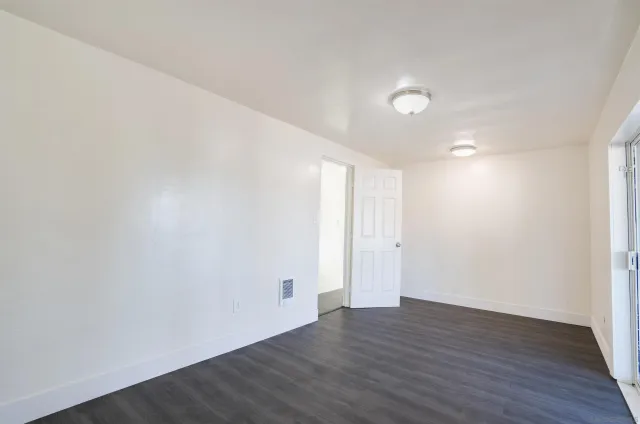 a view of an empty room with wooden floor