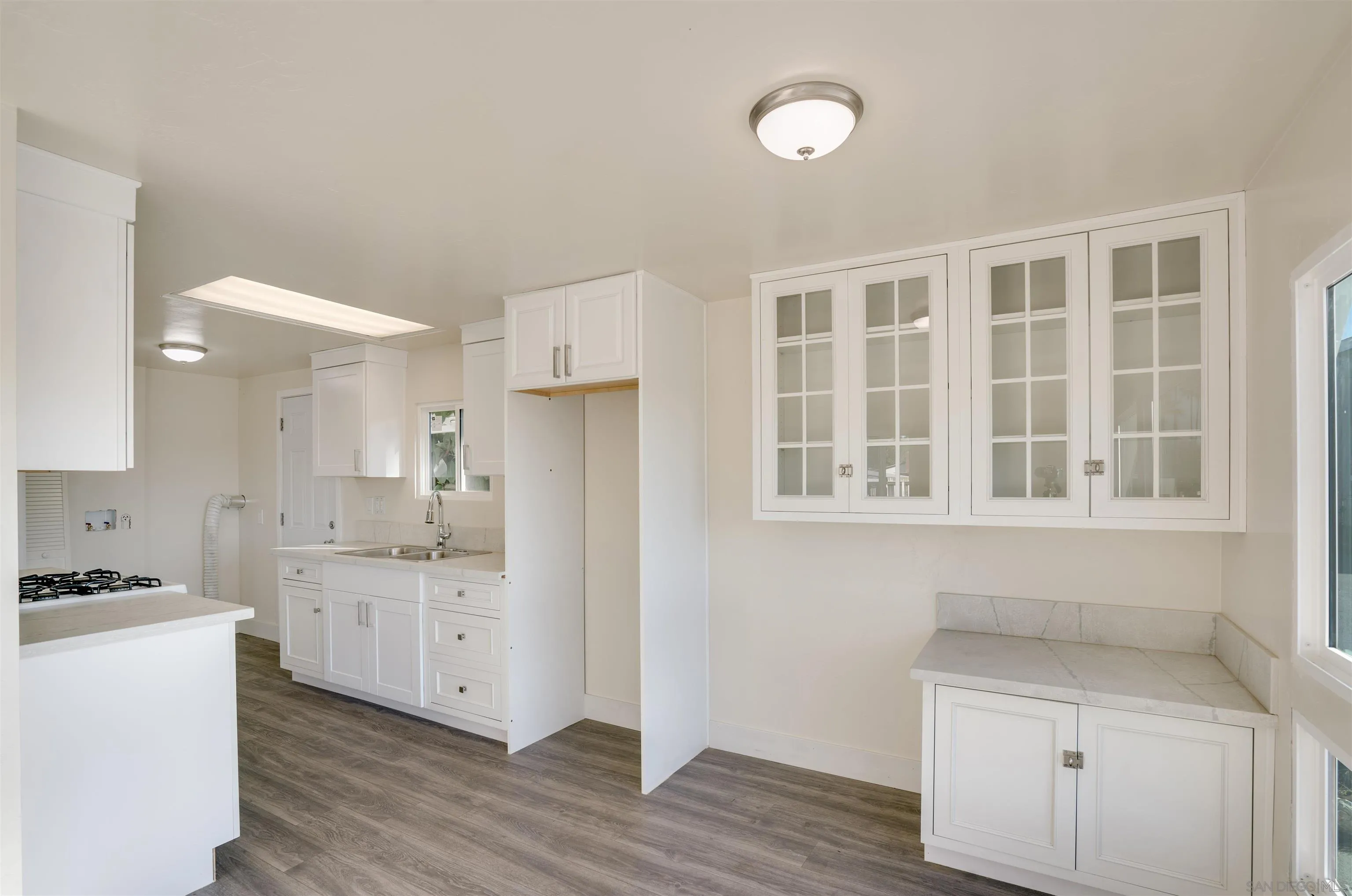 13490 Highway 8 Business, Unit SPC 14 Lakeside, CA 92040 - Photo 6 of 25 a kitchen with white cabinets and wooden floor