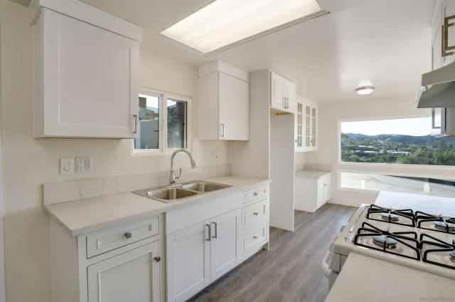 a kitchen with stainless steel appliances a sink stove and cabinets