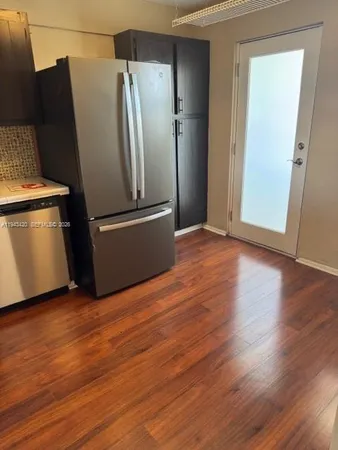 a view of a kitchen with wooden floor and electronic appliances
