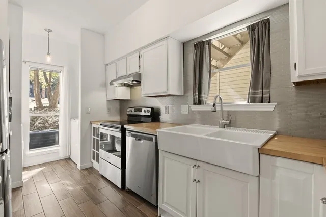 a kitchen with a sink cabinets stainless steel appliances and a window
