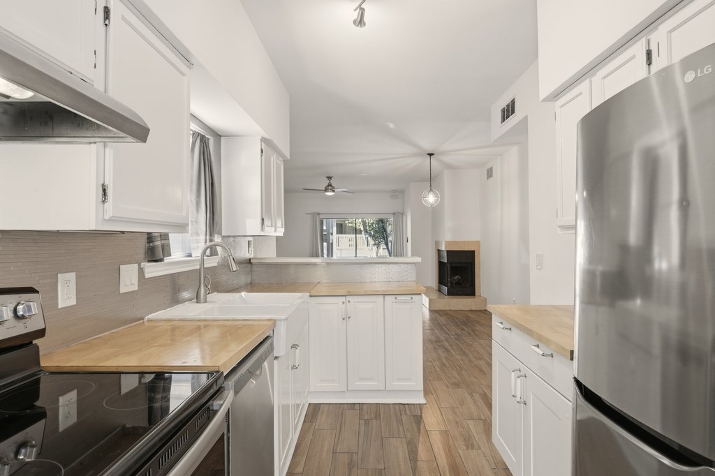 2450 Wickersham Lane, Unit 1006 Austin, TX 78741 - Photo 12 of 27 a kitchen with a refrigerator sink and cabinets