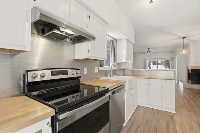 a kitchen with a stove cabinets and wooden floor