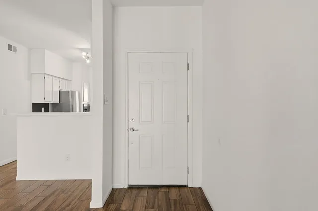 a view of a hallway with wooden floor and closet