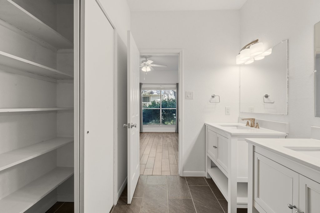 2450 Wickersham Lane, Unit 1006 Austin, TX 78741 - Photo 19 of 27 a bathroom with a double vanity sink and mirror