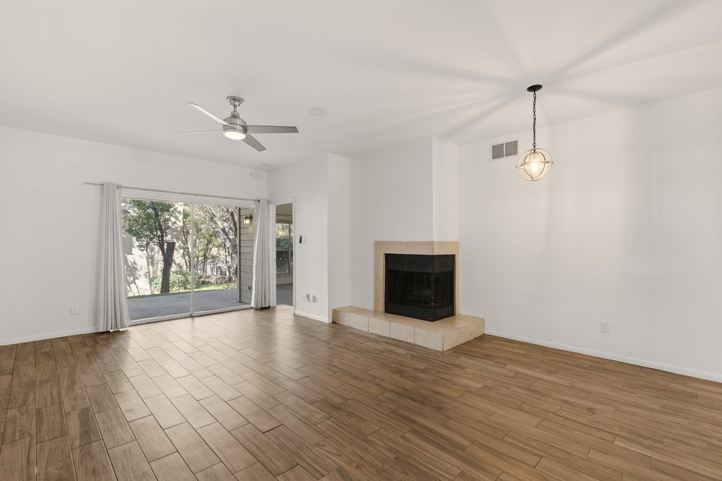 2450 Wickersham Lane, Unit 1006 Austin, TX 78741 - Photo 3 of 27 a view of an empty room with wooden floor fireplace and a window