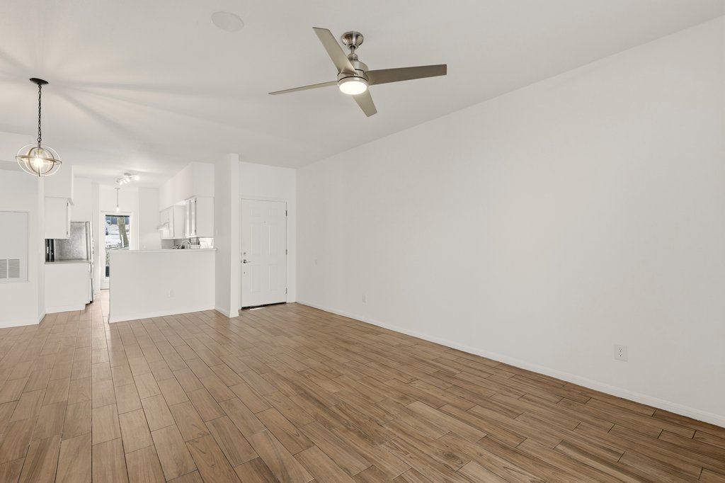 2450 Wickersham Lane, Unit 1006 Austin, TX 78741 - Photo 7 of 27 a view of an empty room with wooden floor and a ceiling fan