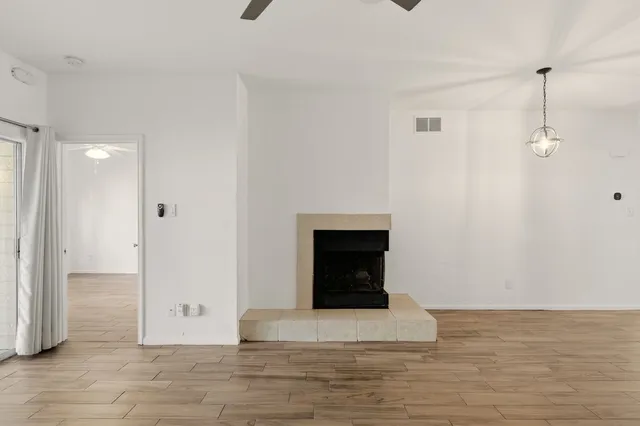 a view of a livingroom with wooden floor and a fireplace
