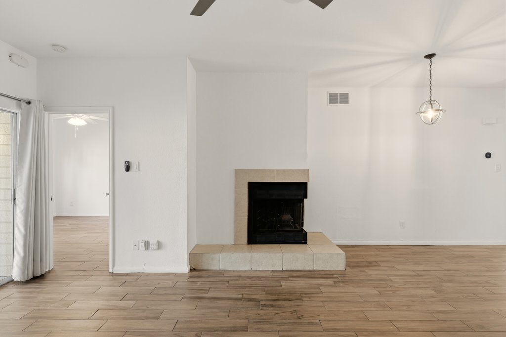 2450 Wickersham Lane, Unit 1006 Austin, TX 78741 - Photo 9 of 27 a view of a livingroom with wooden floor and a fireplace