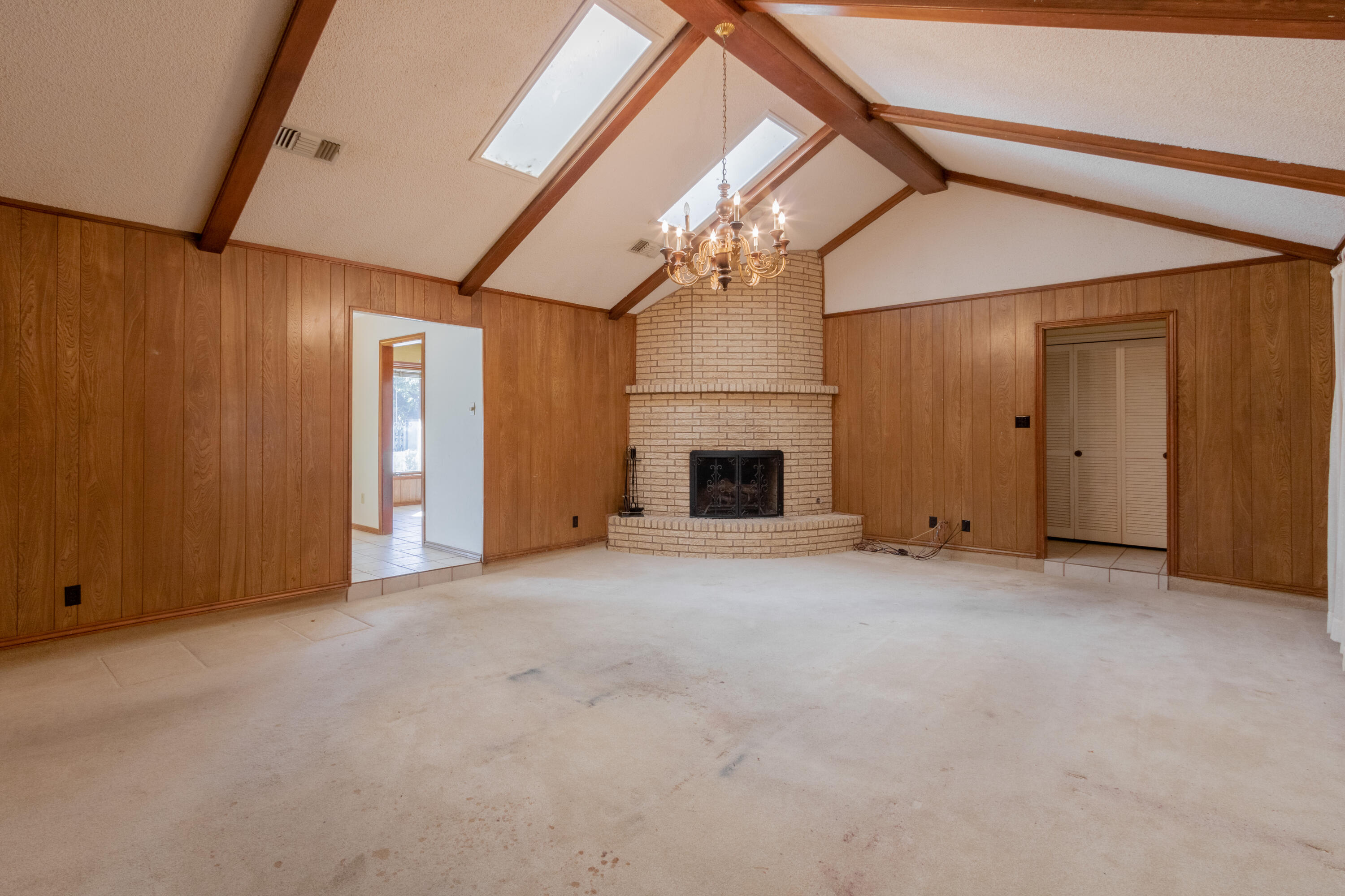 5714 73rd Street Lubbock, TX 79424 - Photo 11 of 38 an empty room with a fireplace and chandelier