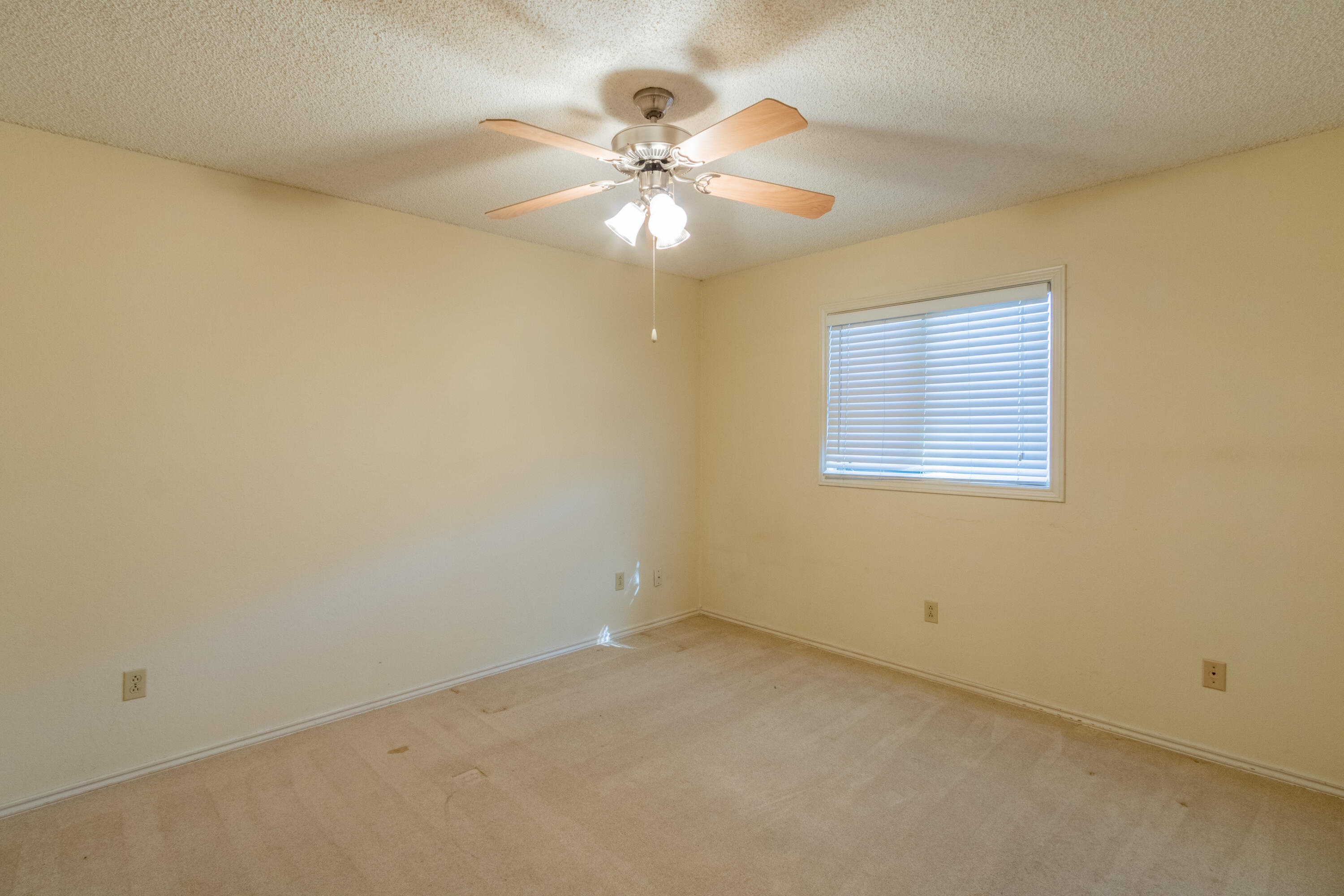 5714 73rd Street Lubbock, TX 79424 - Photo 27 of 38 an empty room with a window and a chandelier fan