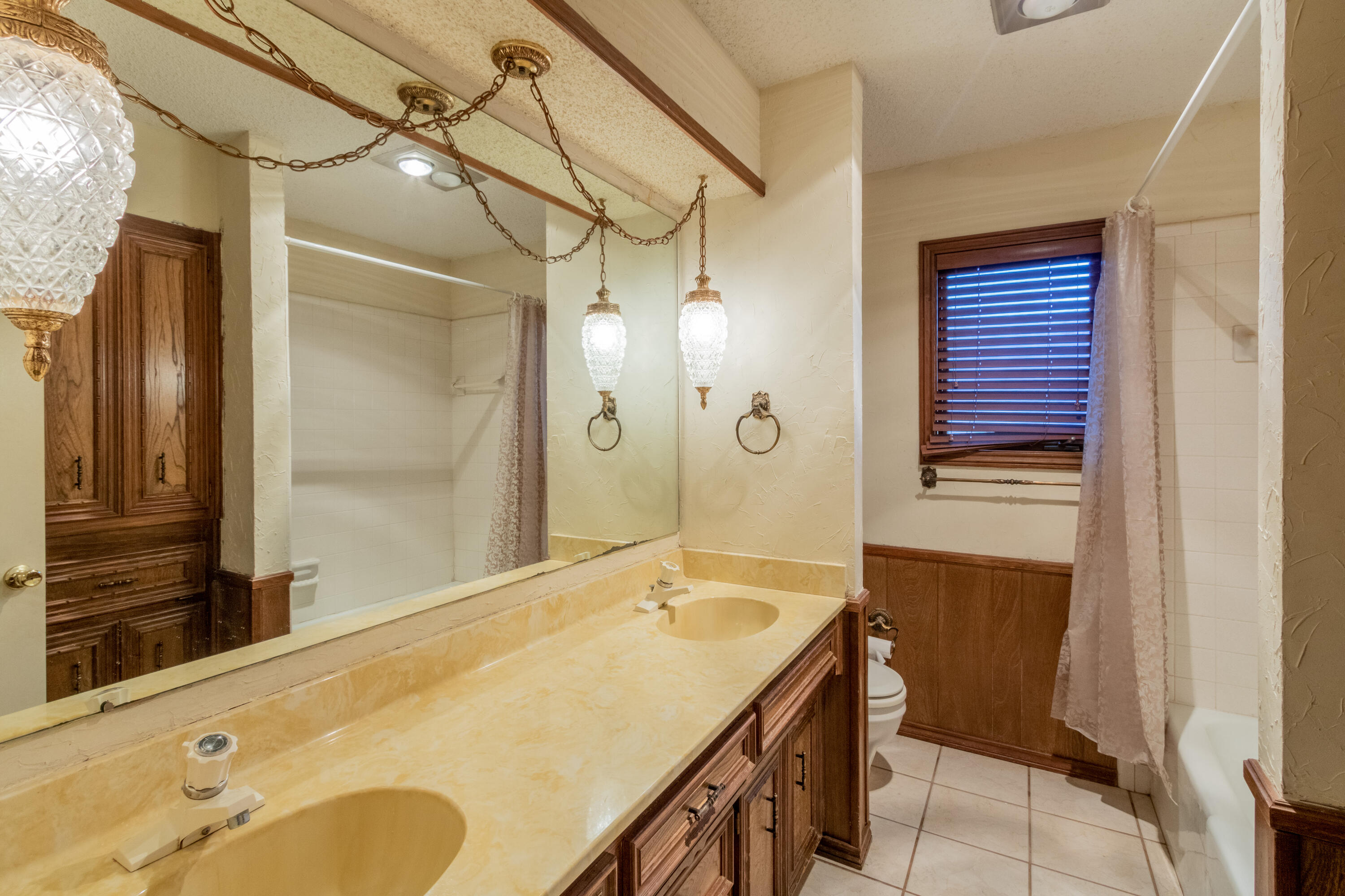 5714 73rd Street Lubbock, TX 79424 - Photo 29 of 38 a bathroom with a granite countertop sink and a mirror